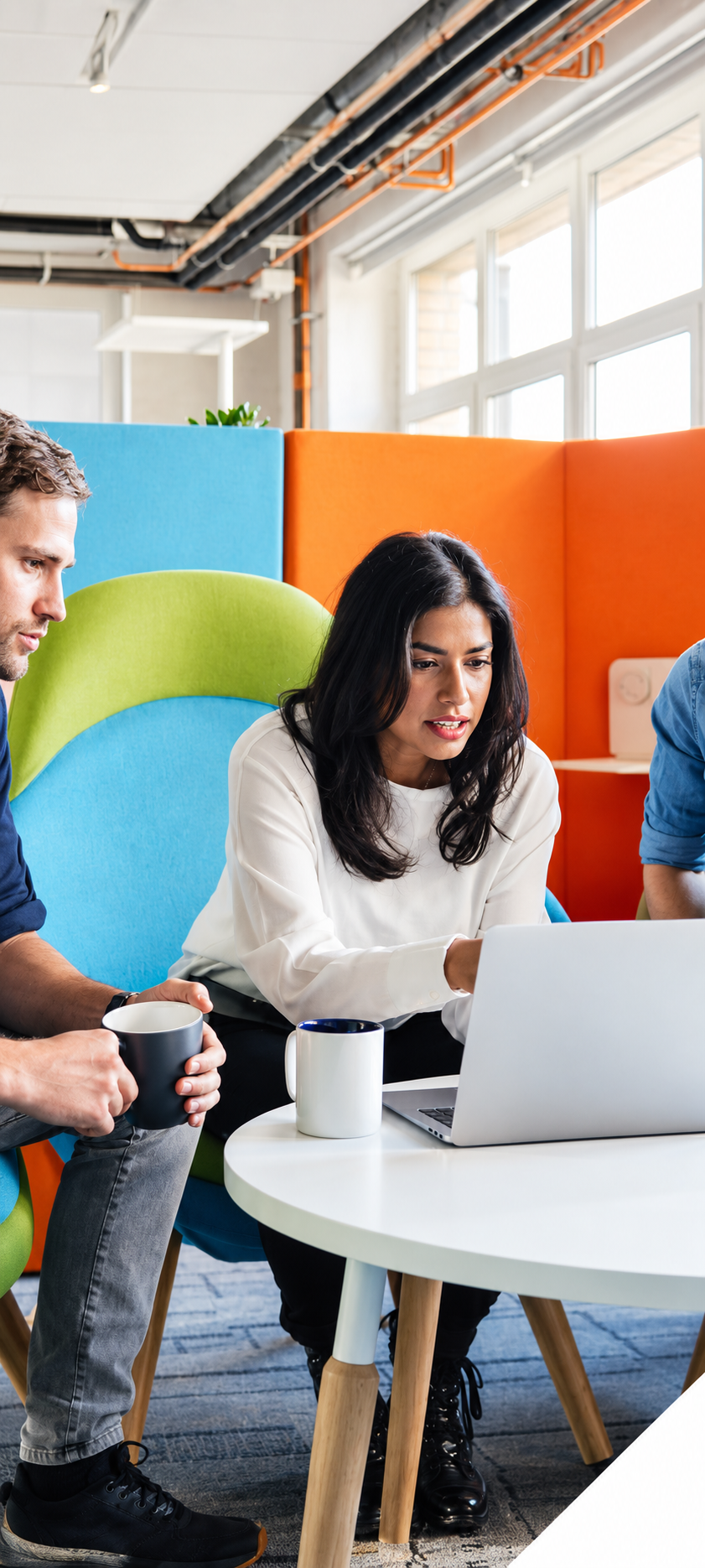 Colleagues collaborating around a laptop